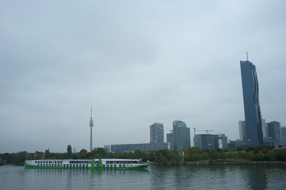 Een cruiseschip vaart voor het Donauinsel te Wenen