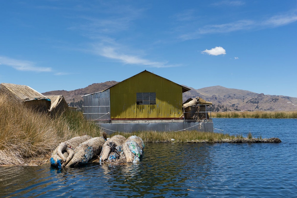 Afgedankte rietboten, opgevuld met plastic, bij de drijvende eilanden in het Titicaca-meer in Peru